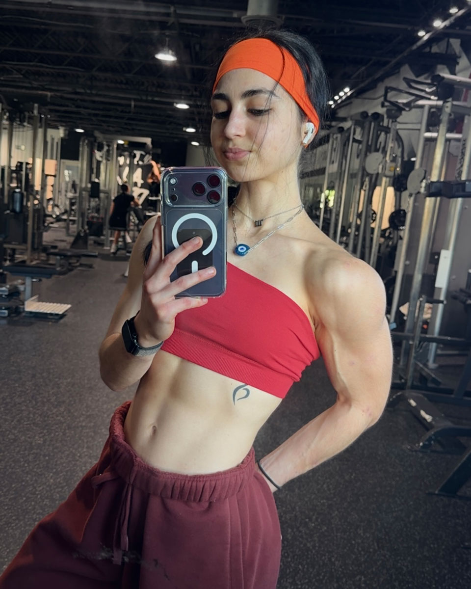 The coach is posing at the gym.